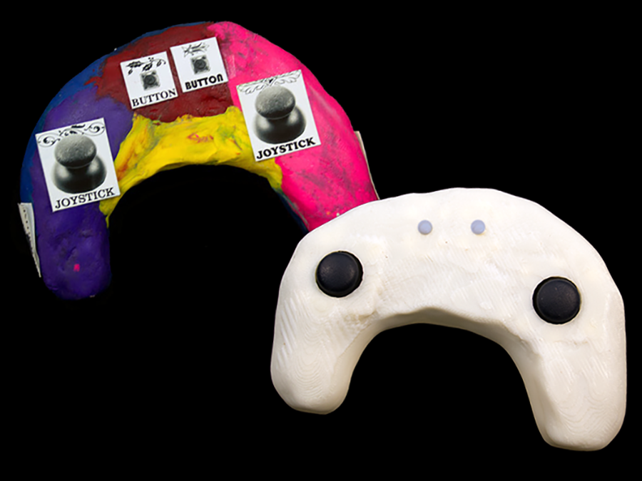 Two game controllers, one made from clay and stickers and one 3D printed from the scanned clay model.